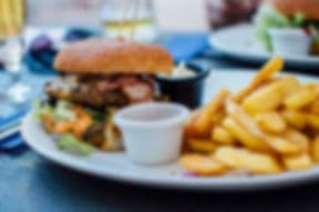Burger with fries on plate at restaurant table