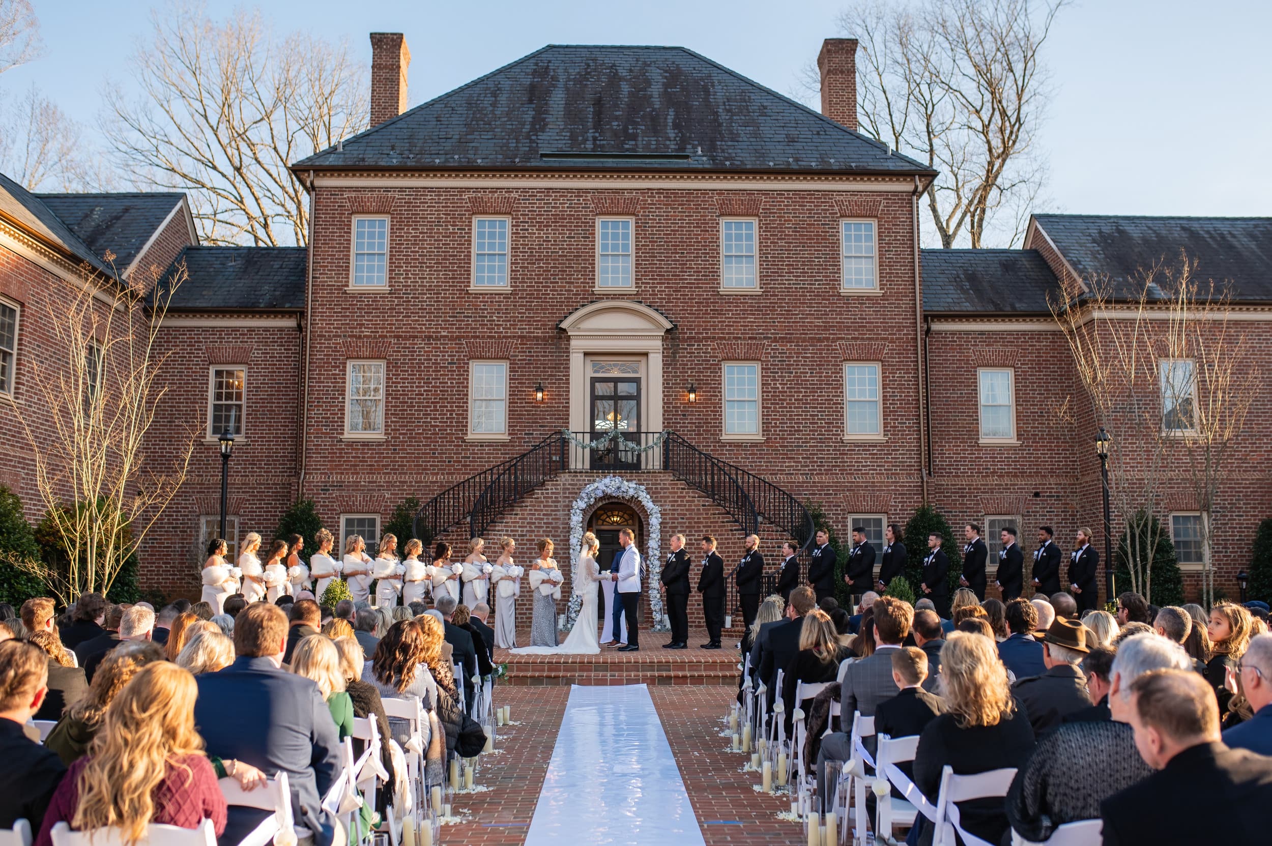 Brick mansion exterior with wedding ceremony in courtyard