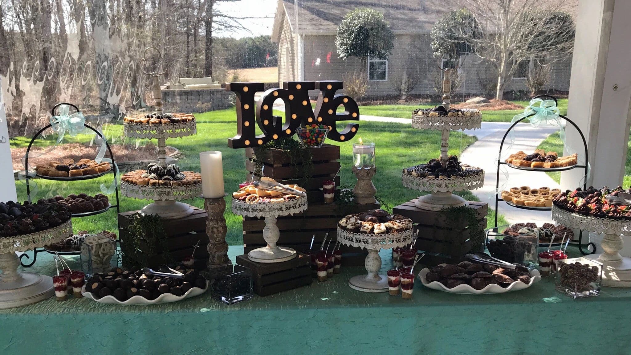 Dessert table with pastries, chocolates, and LOVE sign