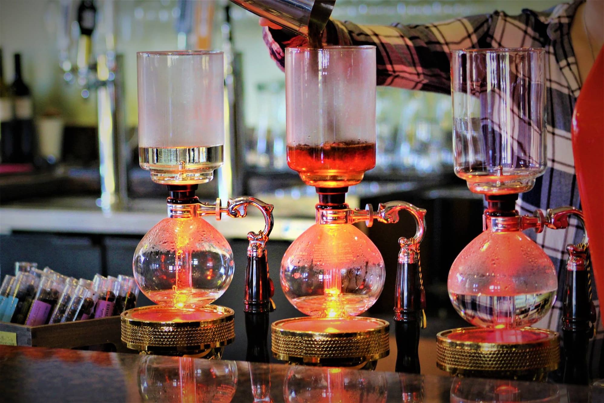 Siphon coffee brewers brewing coffee at counter