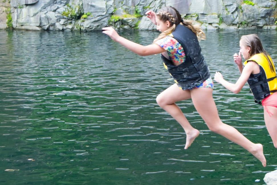 Children jumping into quarry water