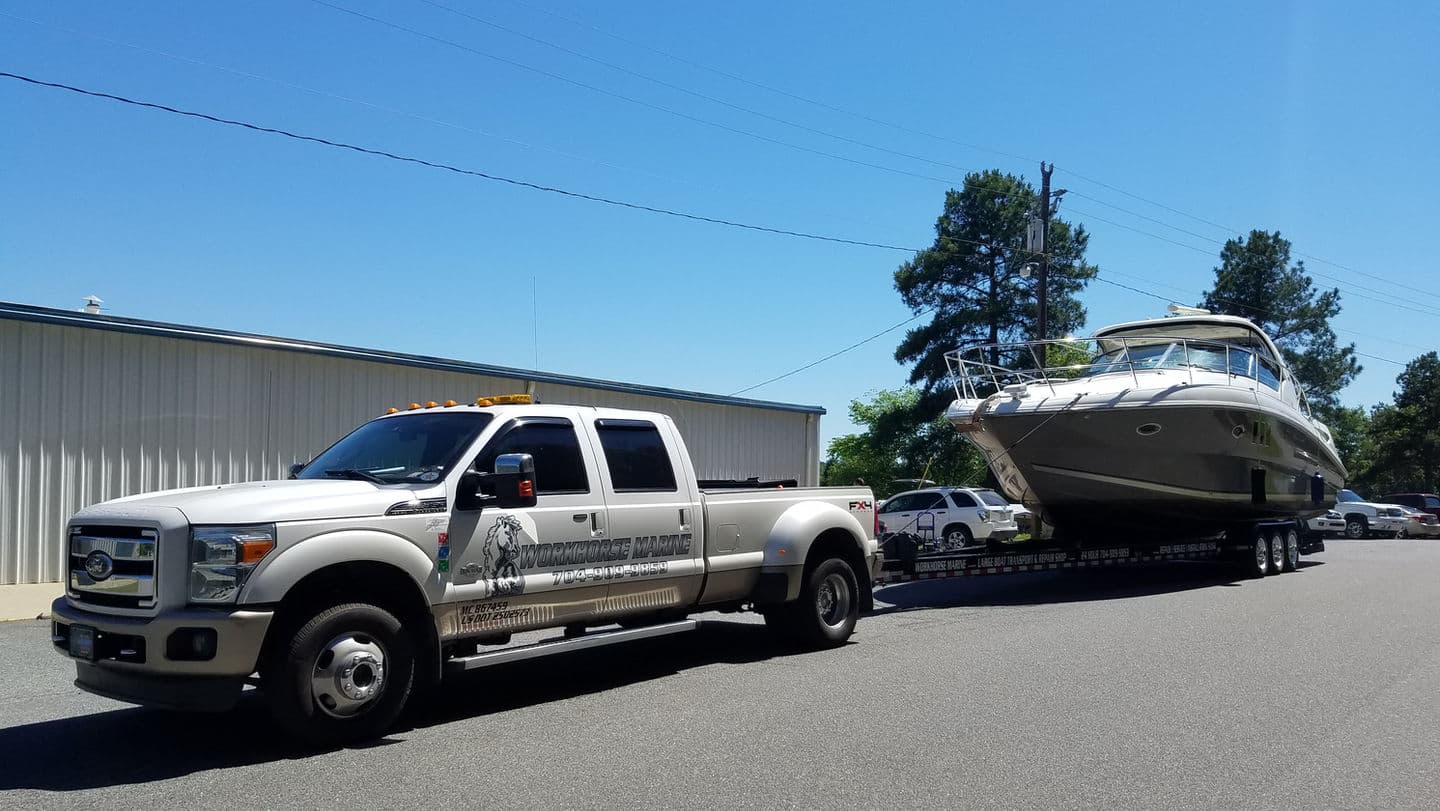 White pickup truck towing large boat