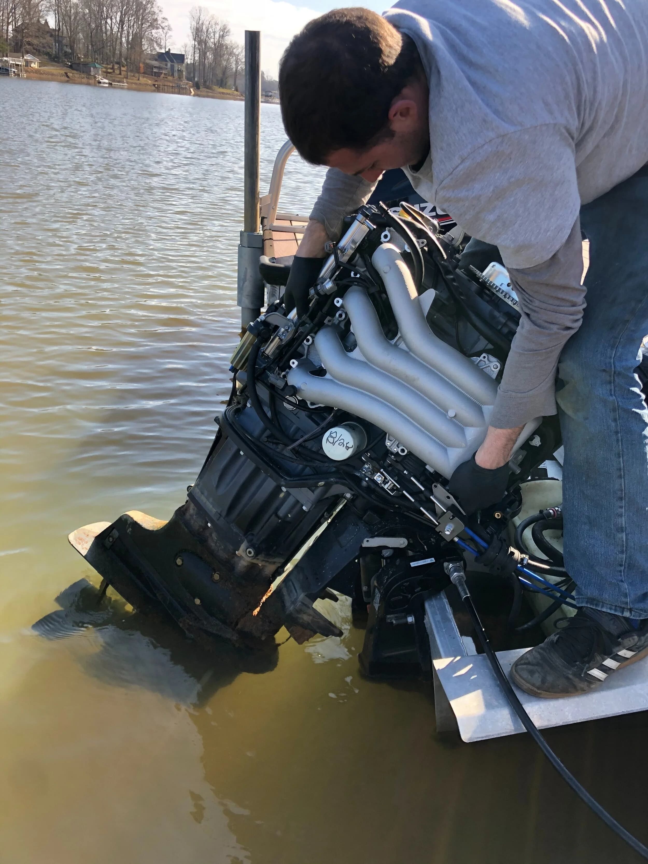 Technician working on boat motor in water