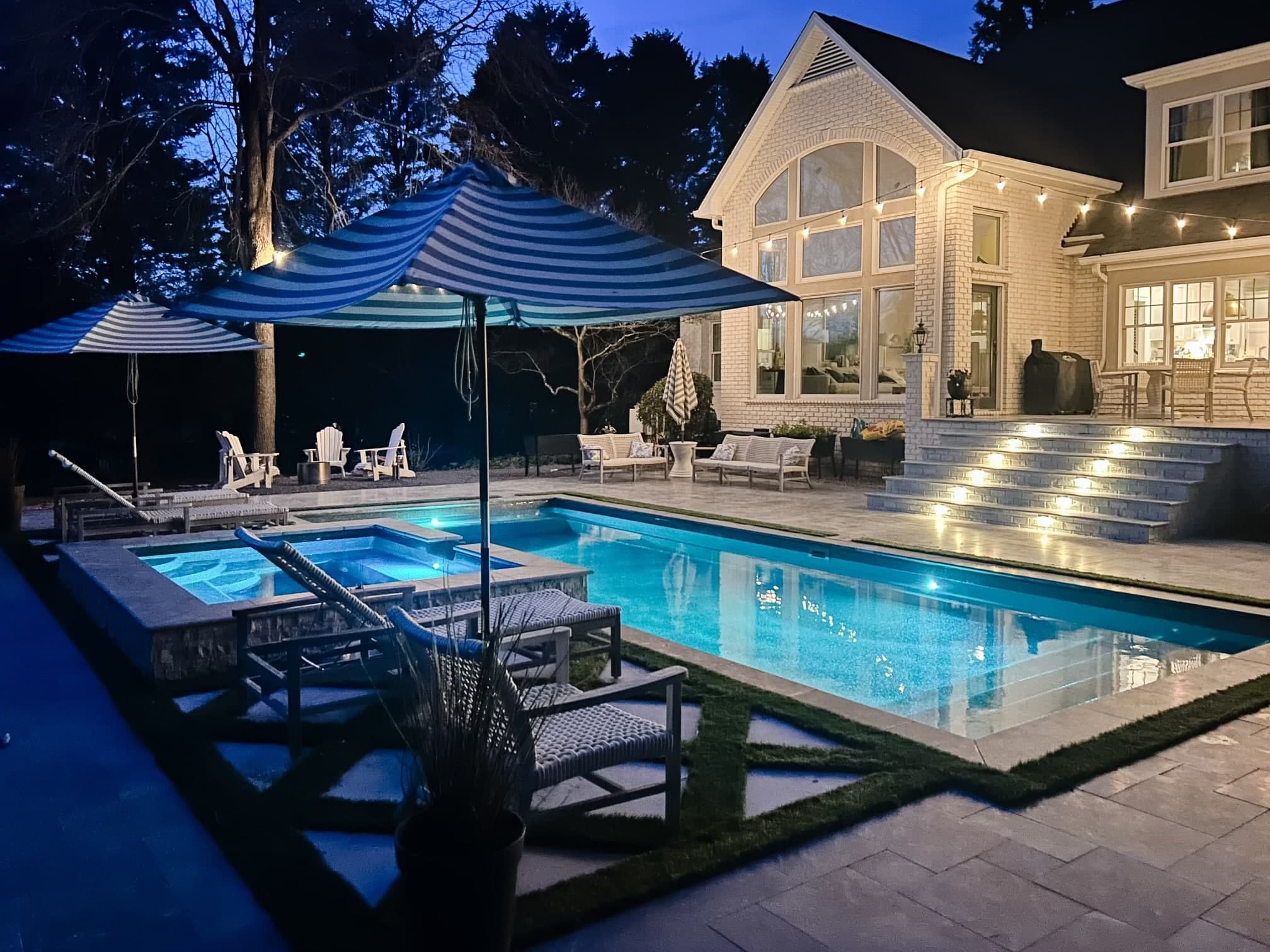 Illuminated pool at night with umbrellas