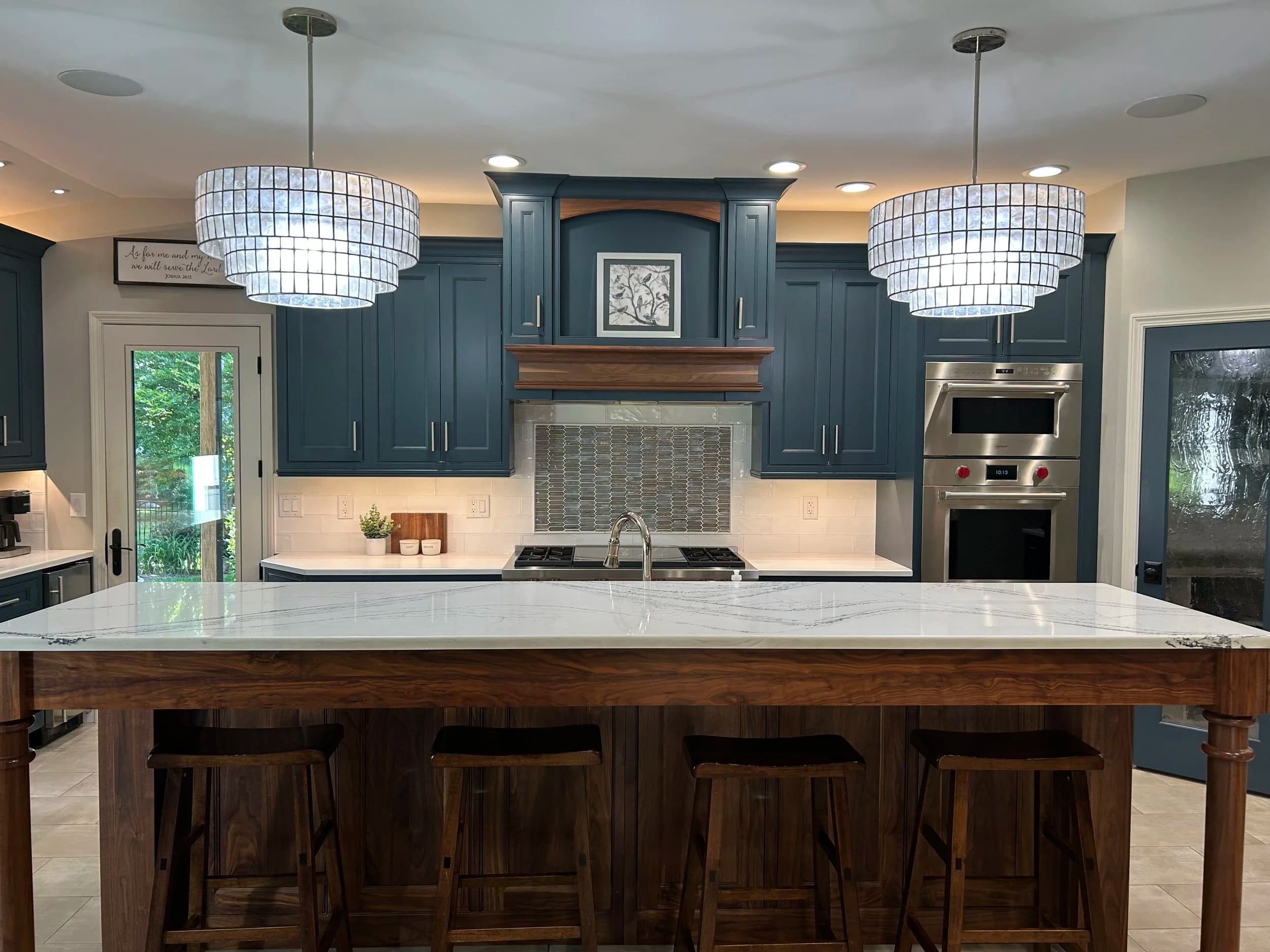 Kitchen with dark blue cabinets and marble counters