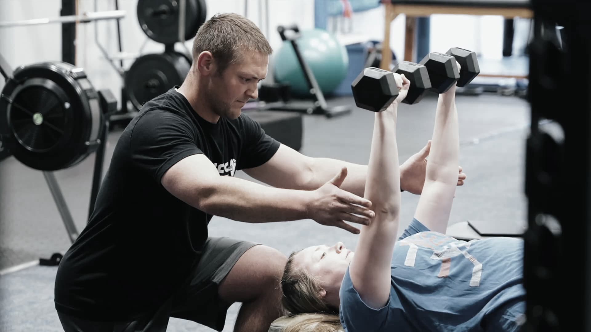 Personal trainer coaching client dumbbell exercise