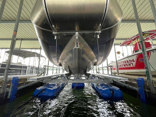 Boat lift holding large vessel in covered facility