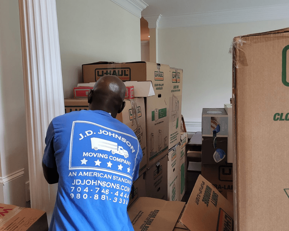 Moving company worker loading boxes into home