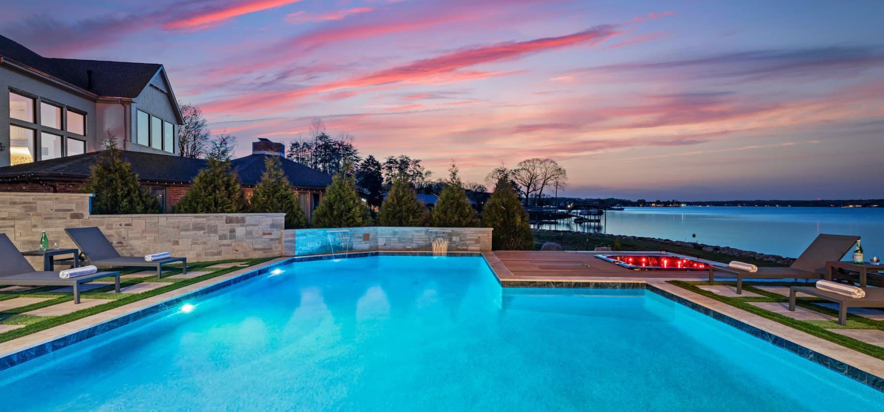 Lakefront home with illuminated swimming pool