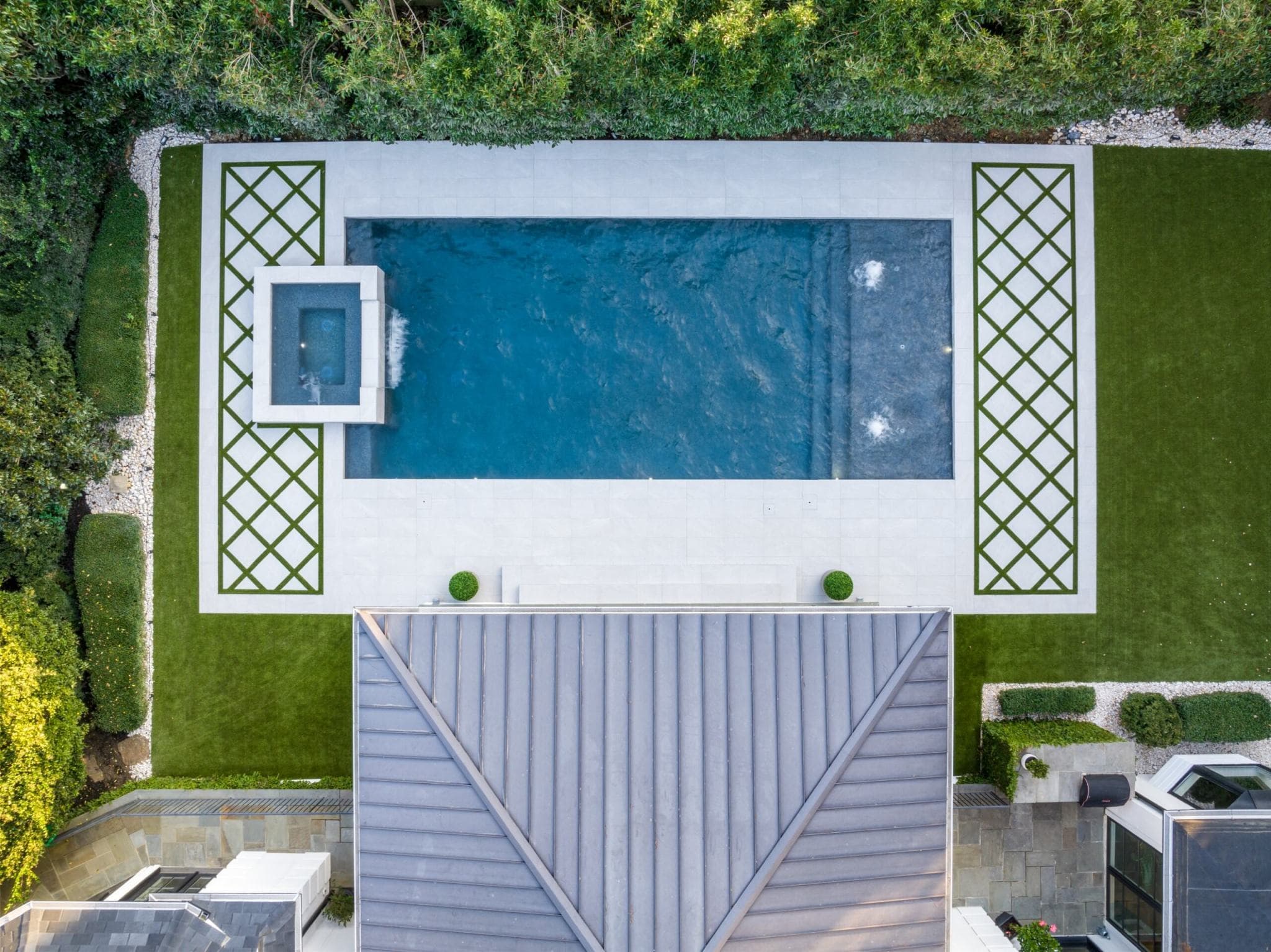 Aerial view of residential pool with deck and landscaping