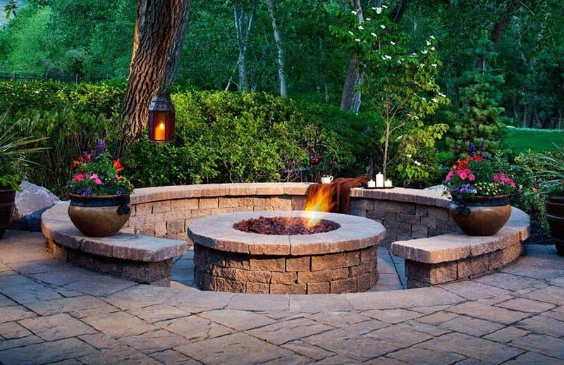 Stone fire pit seating area with landscaping