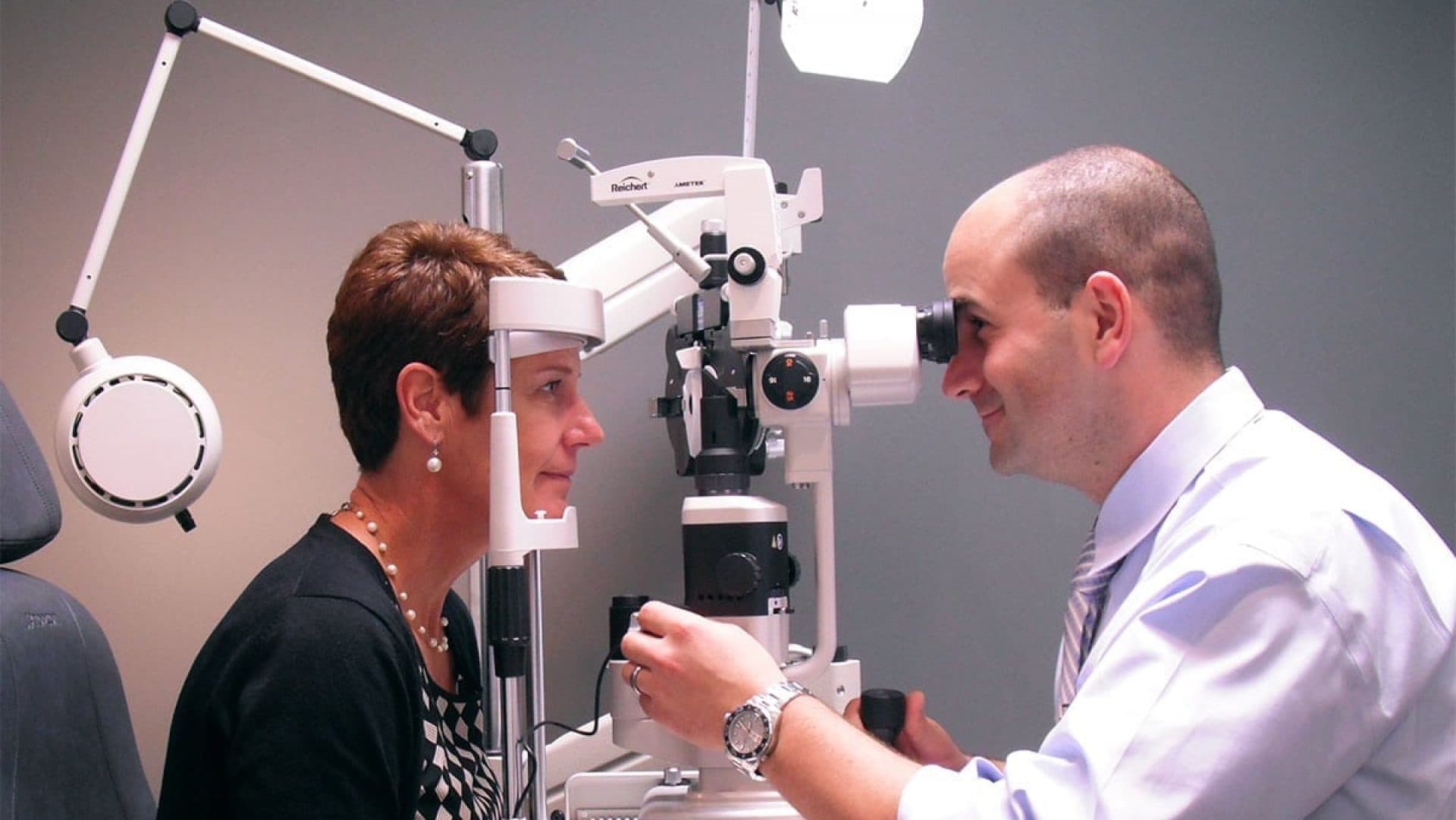 Optometrist performing eye exam with patient