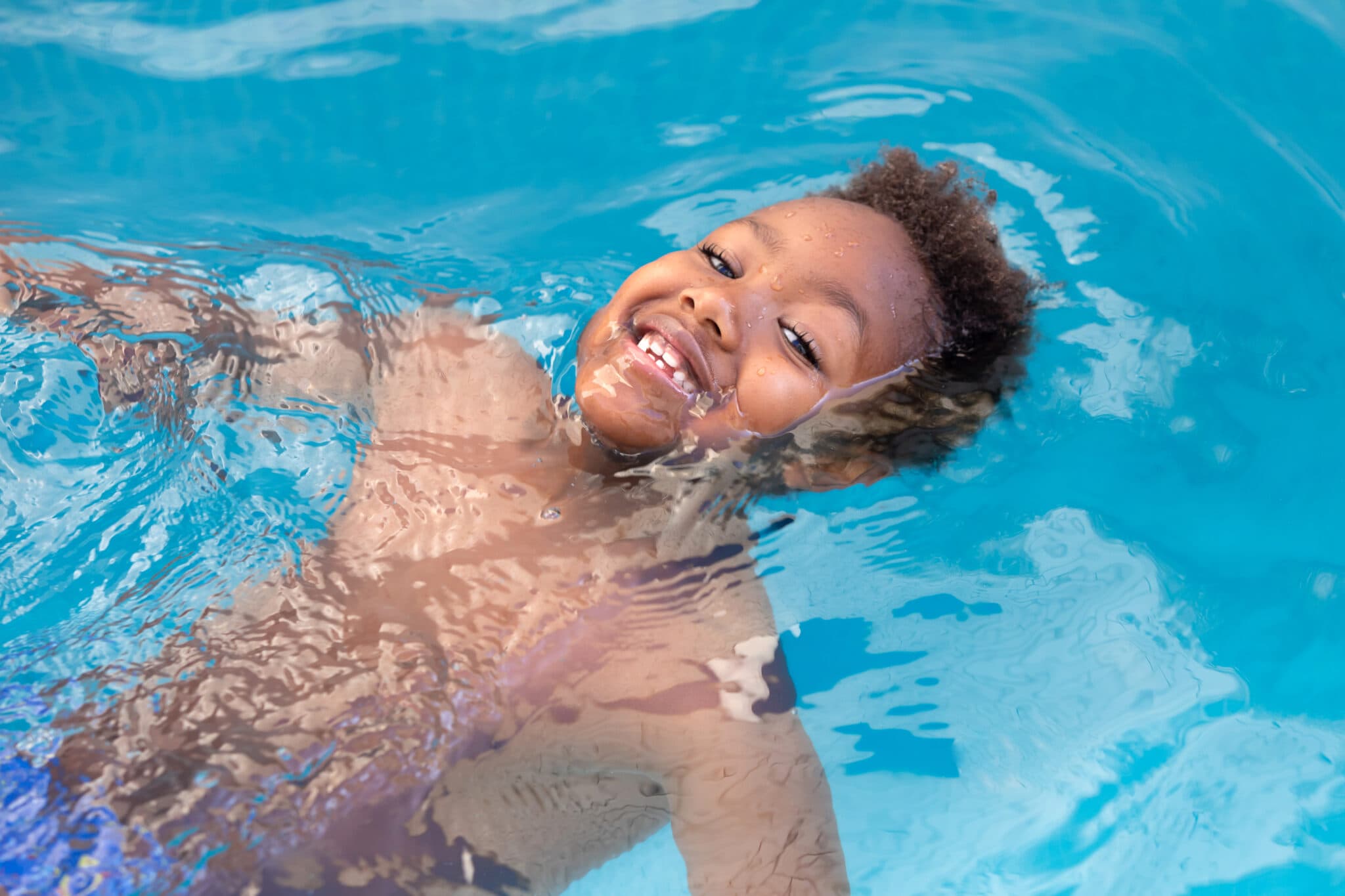 Child swimming with instructor in pool