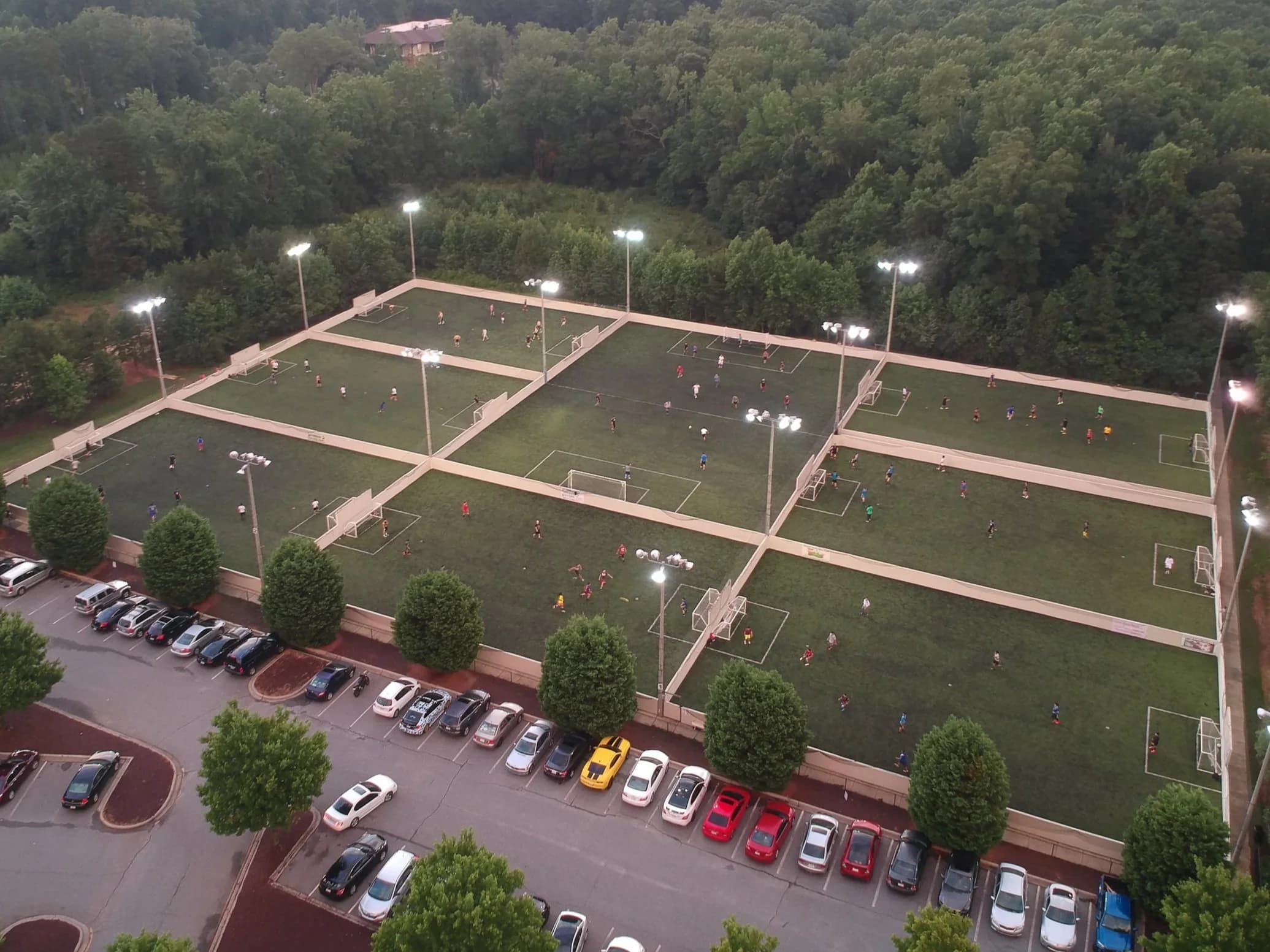 Aerial view of multiple soccer fields with lighting