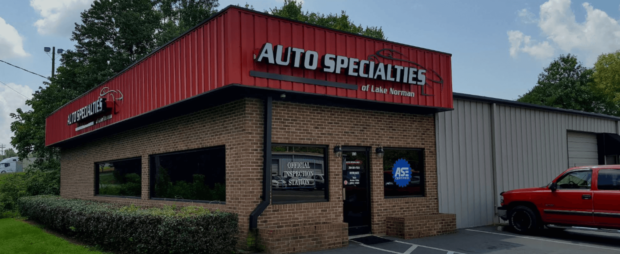 Storefront exterior with red sign and brick building