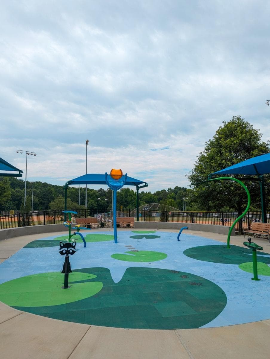 Splash pad with blue ground and green water features
